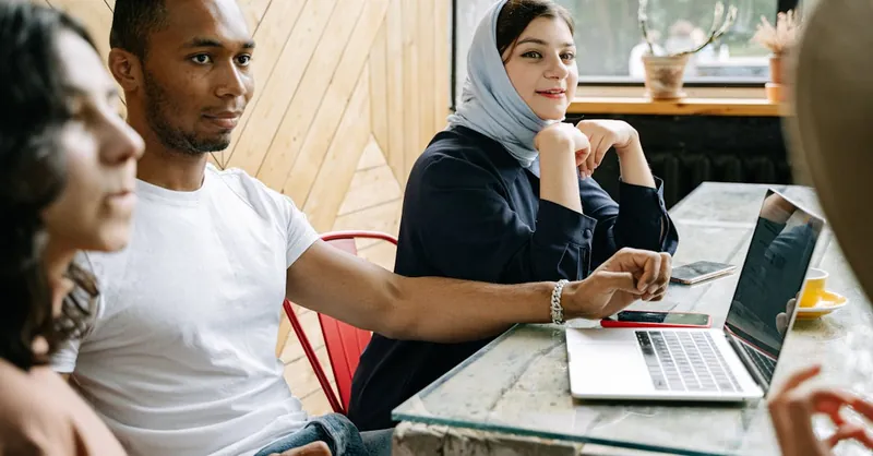 A diverse group of professionals engaged in collaborative work inside a modern workspace.