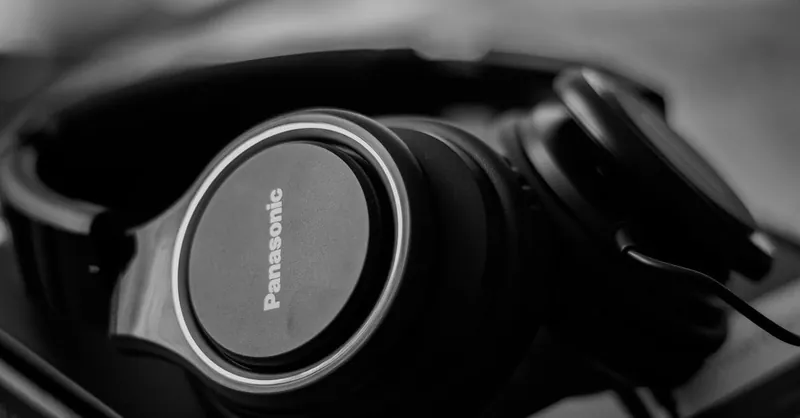 Close-up shot of black headphones with a blurred background in black and white.