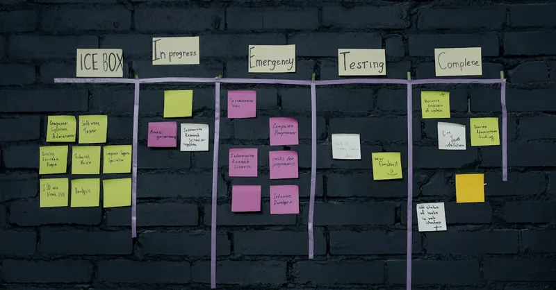 Top-down view of an office Kanban board with colorful sticky notes for task management and organization.