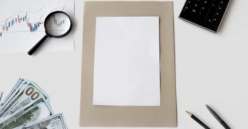 Flat lay of financial tools and blank paper for planning or mockup.