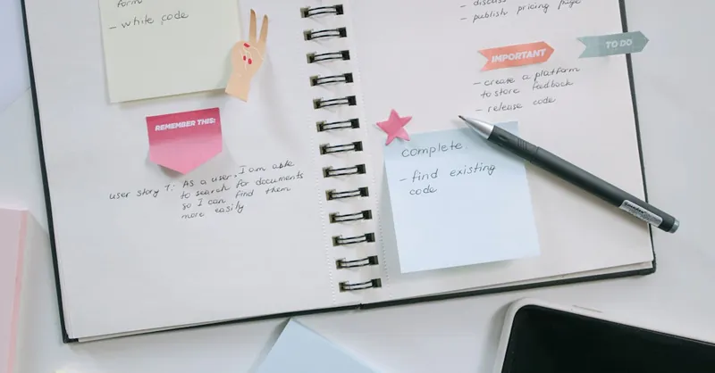 A modern workspace with a notebook, smartphone, and sticky notes emphasizing productivity and organization.
