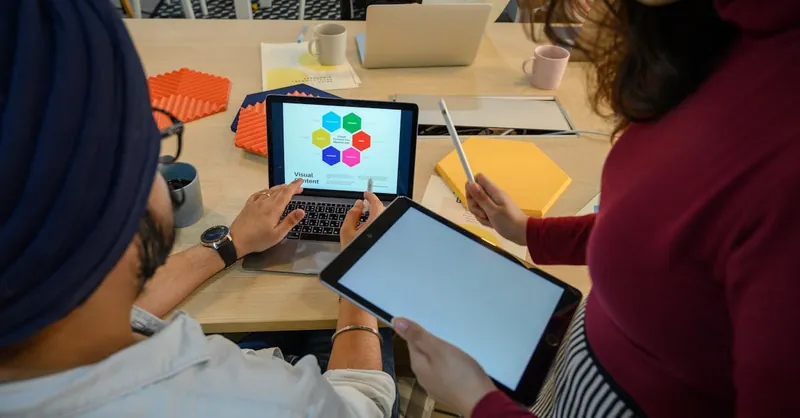 Creative meeting with digital devices in a modern office, showcasing teamwork and collaboration.