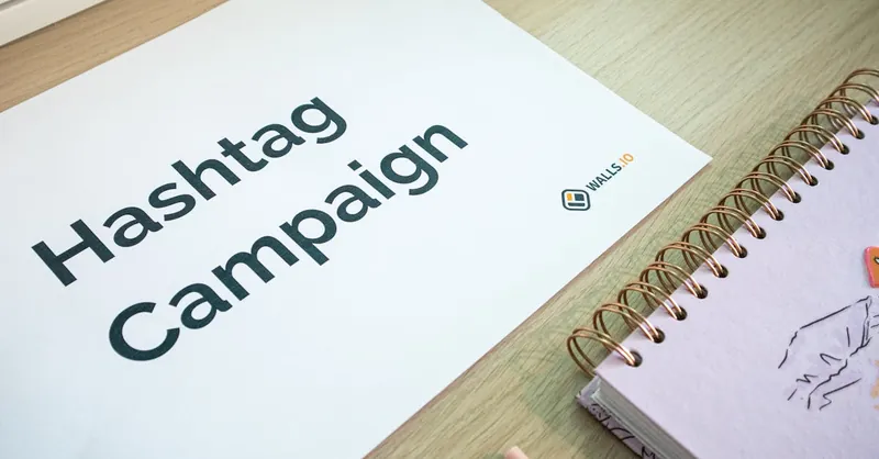 A clean office desk setup featuring hashtag campaign marketing materials and a planner.