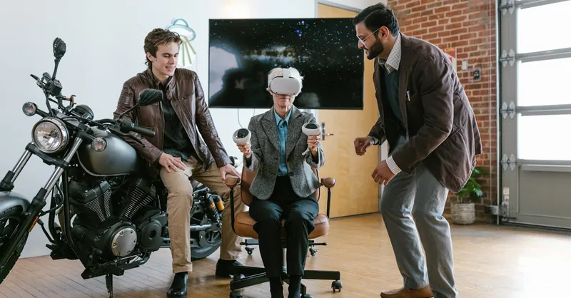 Two men assist a seated colleague with a virtual reality headset in a stylish, brick-walled office.